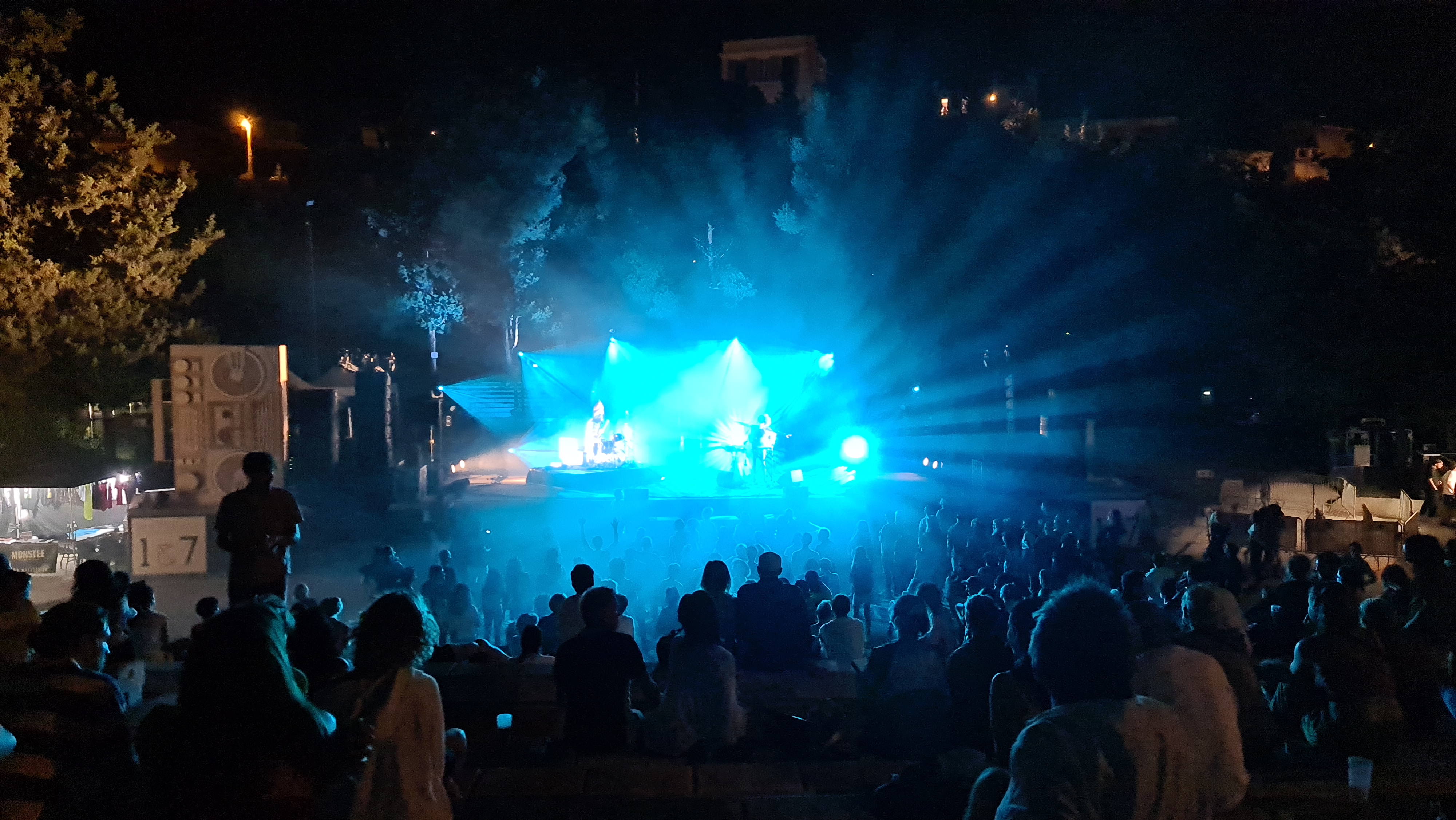 Duo OY on stage at festival de Marseile. You can see the crowd and the band from afar, lit in spectaculour blue light.